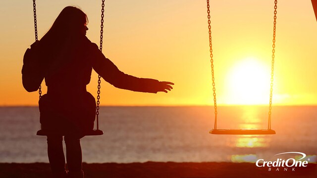 As the sun sets, a silhouetted woman on a swing reaches out to an empty swing beside her. This may represent how a loved one’s death could impact you financially and in other ways.
