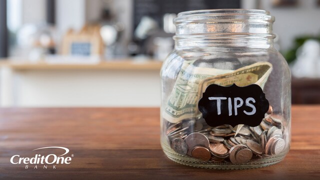 A tip jar sitting on a countertop.