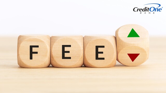 Four wooden blocks with markings on their faces are lined up in a row. The first three spell out the word “Fee,” while the last is rotating to reveal upward and downward arrows. This represents weighing the pros and cons of a credit card with an annual fee.