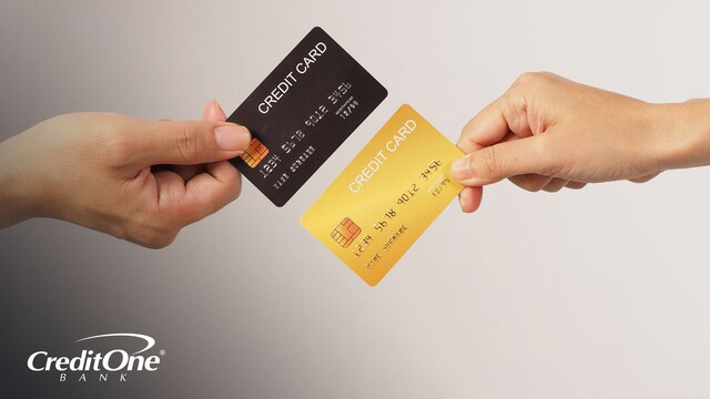 Two individuals hold different credit cards — one black, the other gold — against each other, as if comparing them. This can represent the comparison of secured and unsecured credit cards.